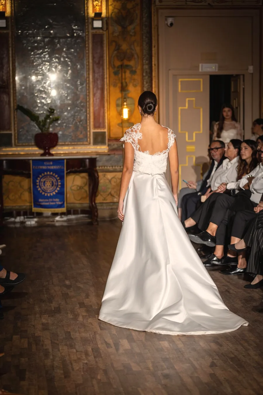 Dettaglio della schiena di un abito da sposa in raso realizzato su misura in atelier